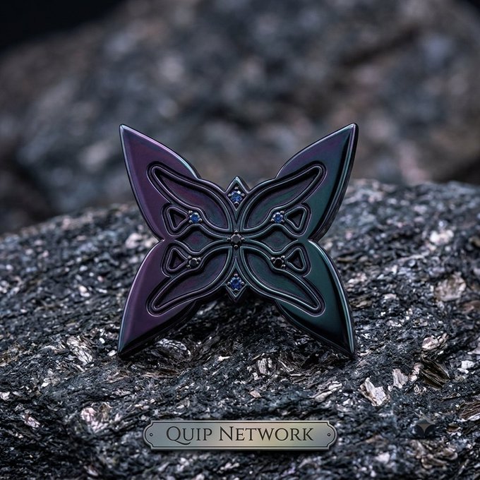 A decorative metallic butterfly emblem with iridescent purple and green coloring and small gem accents rests on a dark, sparkly surface, labeled 'Quip Network'.
