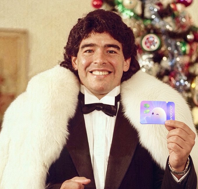 A vintage holiday portrait featuring a smiling man in a white tuxedo shirt, black bowtie, and white fur-collared jacket, holding up an 'Apple One' subscription card in front of a decorated tree.