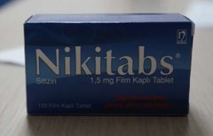 A blue and white box of Nikitabs 1.5 mg film-coated nicotine tablets sits on a tiled surface, indicating the user is showing the smoking cessation product they previously used before quitting nicotine eight months ago.
