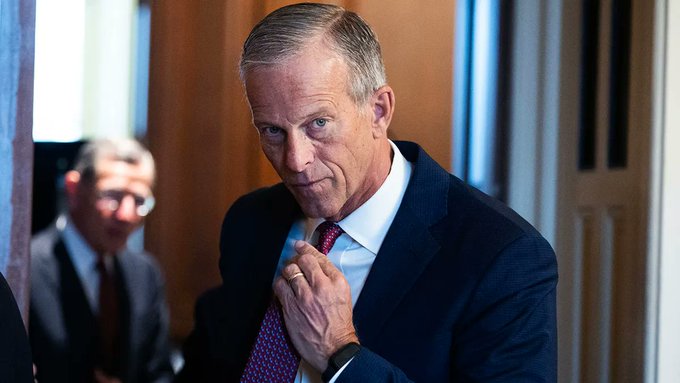 Sen. Majority Leader John Thune, wearing a dark suit and adjusting his red patterned tie, appears focused as he prepares to advance the Clarity Act with a cloture filing ahead of recess—though questions remain about whether he will follow through on his stated intent.