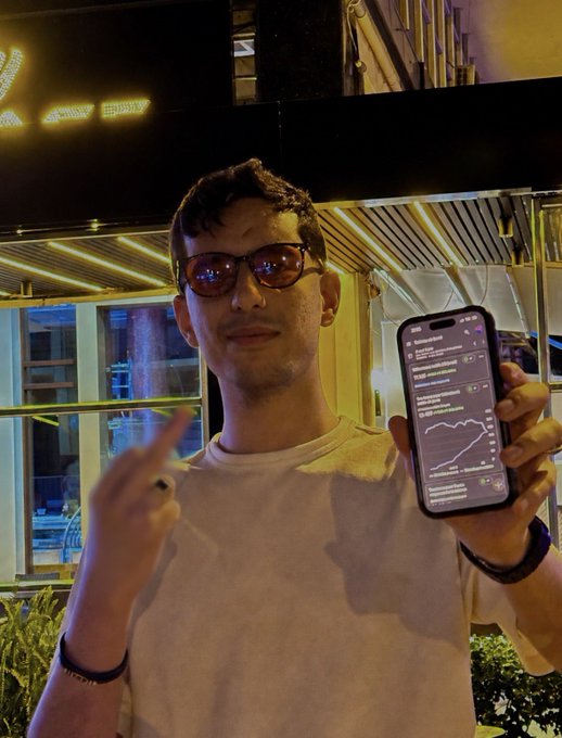 A man wearing sunglasses holds up his phone with a graph displayed, possibly showing his work or hobby related to apps. The image seems to be about sharing information, ideas, or content through phones as a way of communication and collaboration.