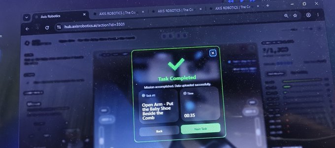 A computer screen showing an "Axis Robotics" platform with a "Task Completed" notification for "Open Arm - Put the Baby Shoe Beside the Comb" mission on hub.axisrobotics.ai.