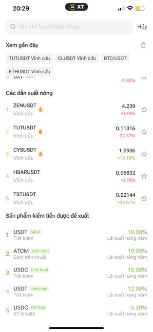 A mobile app screenshot (XT app) displaying a cryptocurrency interface in Vietnamese, listing tokens like 'ZENUSDT' (-0.49%) and 'TUTUSDT' (-27.37%), plus savings products like 'USDT' offering 10.00% annual interest.