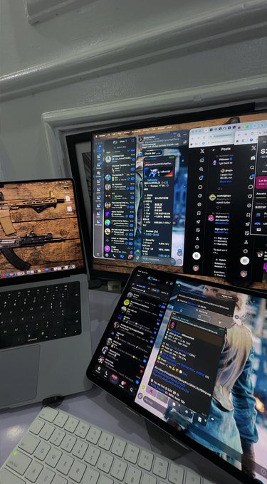The image doesn't relate to the post's content, which claims a gambling payout giveaway. Instead, it shows a multi-screen workspace displaying MacBook screens with Twitter/X feeds and other apps open. The caption should describe the actual image, not fabricate a connection to the dubious giveaway post.