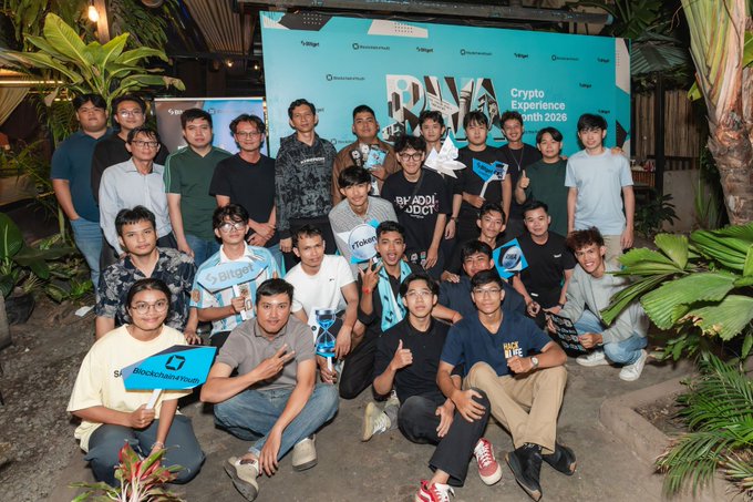 A group of young attendees pose together at the Bitget "Crypto Experience with 2026" event, holding branded signs featuring "Bitget," "Bitgetwallet," and "Blockchain4Youth" in front of a tropical-themed backdrop. The image captures the community-building spirit highlighted in the post, showcasing bright young minds connecting over crypto and blockchain innovation.