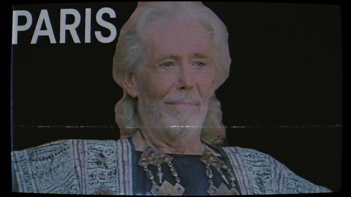 The image features a man with white hair, wearing a robe or jacket that has a patterned design. The text "Paris" can be seen at the top of the image. There are no other objects or people visible in the image.