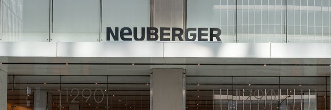 The exterior entrance of a glass building features the name 'NEUBERGER' in large dark letters above the doors, with the address number '1290' visible on the glass.