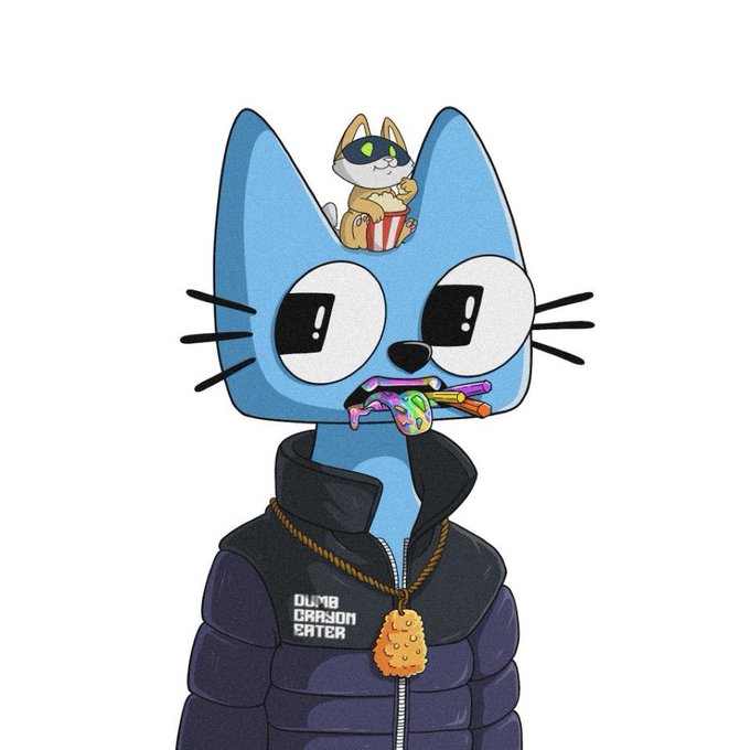 A blue cartoon cat character wearing a dark puffer jacket labeled "DUMB DRAGON EATER" sports a gold cookie medallion, with a small popcorn-eating kitten perched on its head and colorful candies in its mouth. The character name on the jacket aligns with the "dumbcrayoneater" username celebrating the project's $1B milestone.