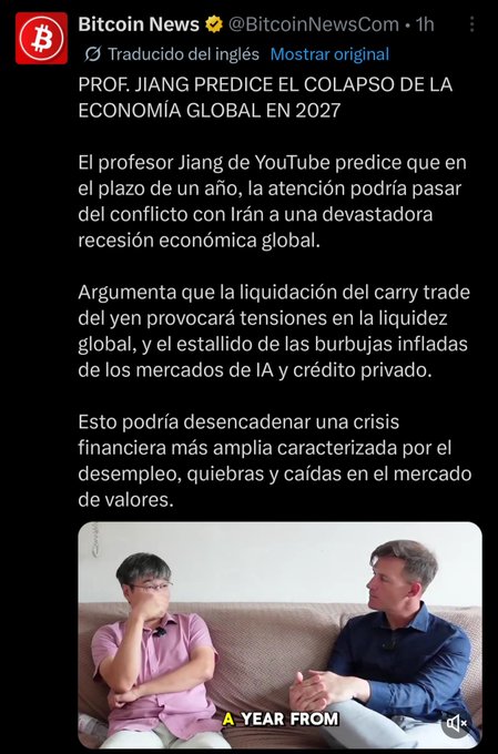 A screenshot of a Spanish-language tweet from @BitcoinNewsCom citing "Prof. Jiang" predicting a 2027 global economic collapse, showing a video still of two men on a couch with the caption "A YEAR FROM," with the accompanying post dismissing Jiang as a Chinese propaganda agent citing his past inaccurate claims about Iran, oil prices, and Bitcoin.