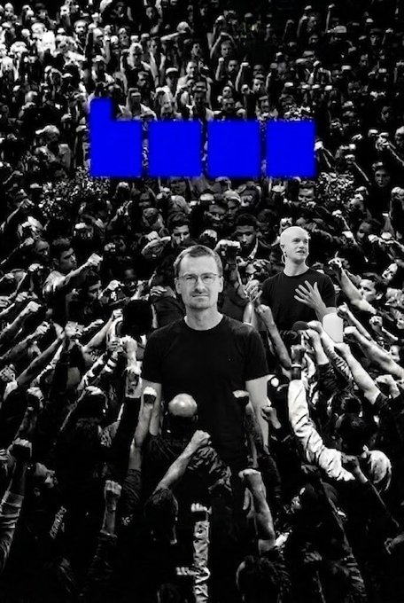 The image features a poster with a man standing in front of a crowd, surrounded by people holding up their hands. The poster has a blue background and white text that reads "BASE. BUILD. BELIEVE." This suggests that the poster is promoting an event or cause related to building a better world through unity and collaboration.