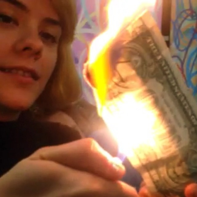 A young girl smiles while burning a U.S. one-dollar bill in an apparent symbolic rejection of fiat currency, reinforcing the post's pitch to invest in the $dasha token as an alternative.