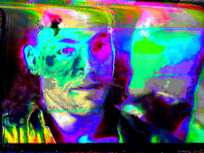 A heavily glitched and color-distorted digital image showing two faces rendered in vibrant neon hues of green, pink, and blue.
