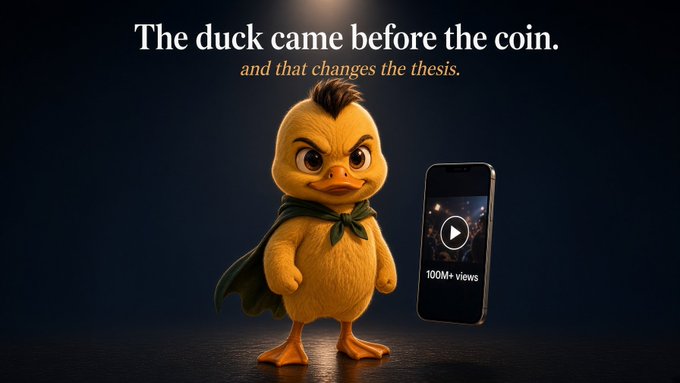An advertisement featuring an angry-looking yellow duck character wearing a green cape, with the text 'The duck came before the coin. and that changes the thesis.' beside a smartphone showing a video player with '100M+ views'.