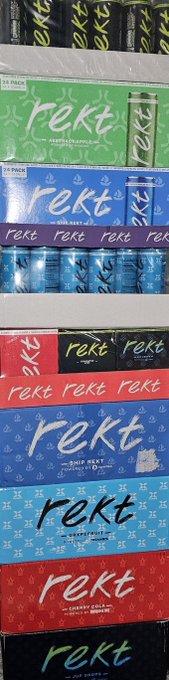 The image features a tall stack of boxes, each containing a different flavor of Rekt soda. The boxes are arranged in various colors such as red, blue, green, and yellow. The text "my @rektdrinks tower is growing! we at chin height m8 $REKT WORLD DOMINATION". This implies that the Rekt brand has been gaining popularity and expanding its reach, with a focus on dominating the market.