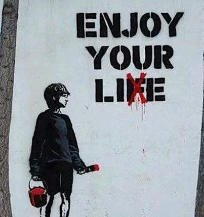 Street art poster reading 'ENJOY YOUR LIFE' with the 'X' crossed out and a red figure replacing it, depicting a small figure holding a paint bucket.