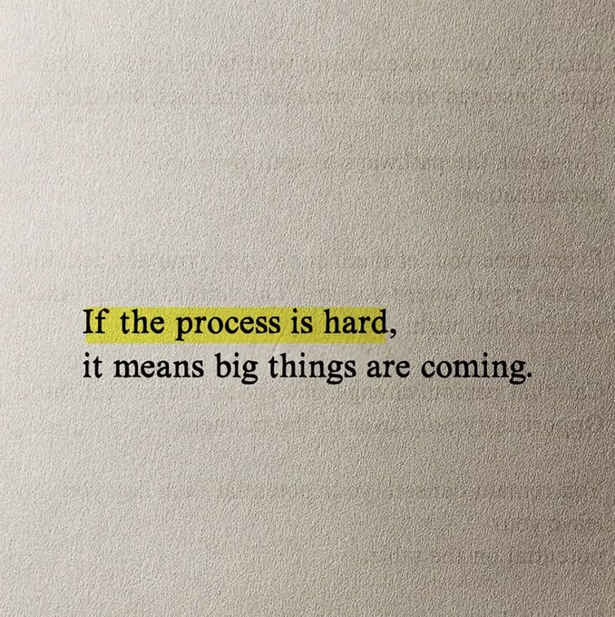 An inspirational quote printed on a textured wall reads: 'If the process is hard, it means big things are coming,' with the first phrase highlighted in yellow.