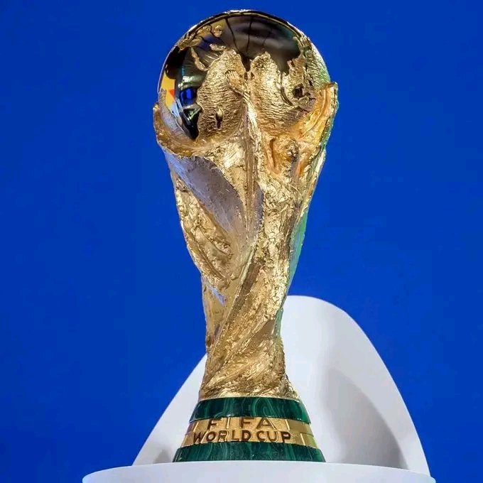 The FIFA World Cup trophy is displayed prominently against a blue background, with "FIFA WORLD CUP" engraved on its green malachite base. This iconic prize ties directly to the post's discussion of the World Cup semi-final match between France and Spain, while the trophy's championship symbolism parallels the "final push" mentioned in Stage 13 of Nomisma Network's Web3 season.
