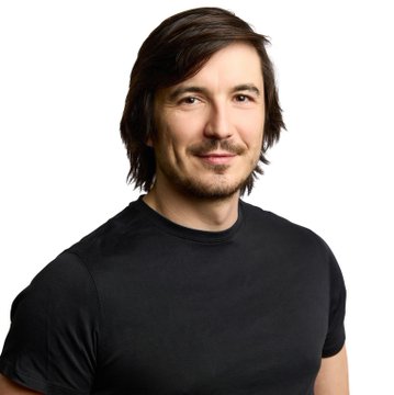 A man with dark hair and a goatee, wearing a black t-shirt, smiles at the camera against a white background. The image appears to be a stock portrait, possibly representing a figure associated with Robinhood ($HOOD), though no specific text or branding is visible in the photo itself.