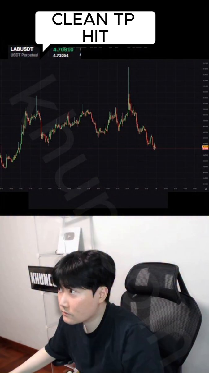 An image that shows a young man wearing black t-shirt sitting behind a computer monitor while watching a video or looking at something else besides his computer screen, possibly a social media post related to the content of the post itself (which may include stock market trends).