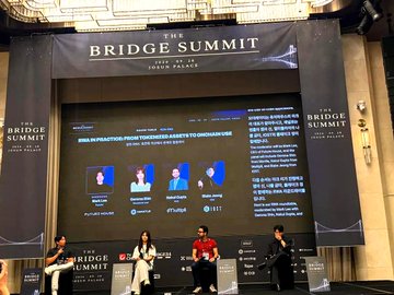 A panel of four participants, including Nakul Gupta, joins the "RWA in Practice" roundtable at The Bridge Summit in Seoul, featuring Mantle and IOST. The large screen behind them displays the panel title and the speakers' names and affiliations.