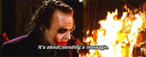 The image features a man with spiky hair, dressed in a purple suit, standing next to a fire that appears to be burning something red or orange. The caption below the image reads "It's about sending a message." This suggests that there is some sort of message being conveyed through this scene, possibly related to the content of the post on social media.