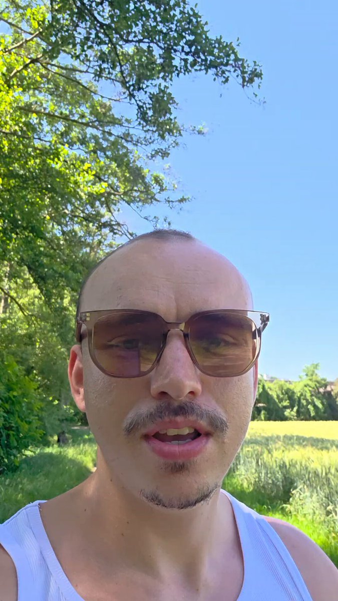 ?" This image features a man wearing sunglasses with a hat, standing outside in an open field. He appears to be taking a photo of himself or capturing a moment outdoors. The man's attire includes sunglasses which can provide protection from bright sunlight and glare, as well as a hat for shade or warmth if needed. The open field suggests a natural setting, possibly during daylight hours when there is sufficient sunlight for outdoor activities like photography. In the accompanying post, players are invited to join the next millionaire trade and expand their wealth by joining forces with other individuals named $MU, $SNDK, and $MRVL.
