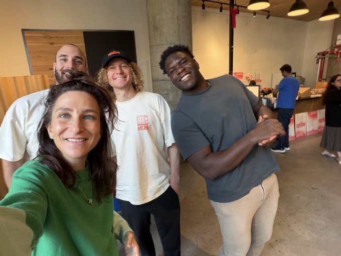 A group of four smiling colleagues pose together for a selfie in what appears to be a casual office or studio space, with one team member wearing a hat displaying "Bankr" branding and another in a shirt featuring "Web3" text, reflecting the @bankrbot team's cohesive and friendly workplace culture.