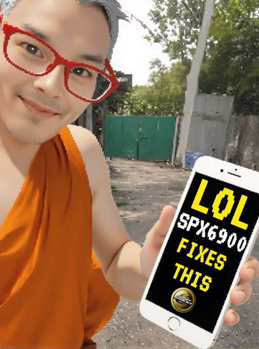 A person wearing an orange shirt and red digital glasses holds up a smartphone displaying the text 'L0L SPX6900 FIXES THIS'.