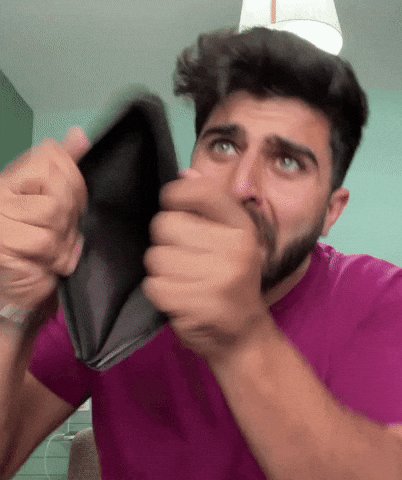 The image features a man holding an open wallet, with his hand covering his face as if he's hiding something or pretending not to see it. The background of the photo shows a green wall, which contrasts with the man's purple shirt. The caption "I'M fried" is written in white text at the bottom right corner of the image.