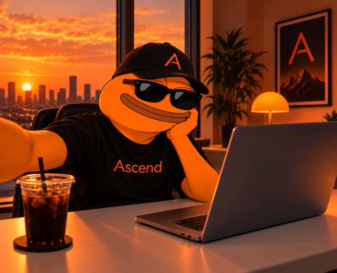 An orange meme character wearing sunglasses and a black 'Ascend' cap and shirt, sitting at a desk with a laptop during a sunset, taking a selfie.