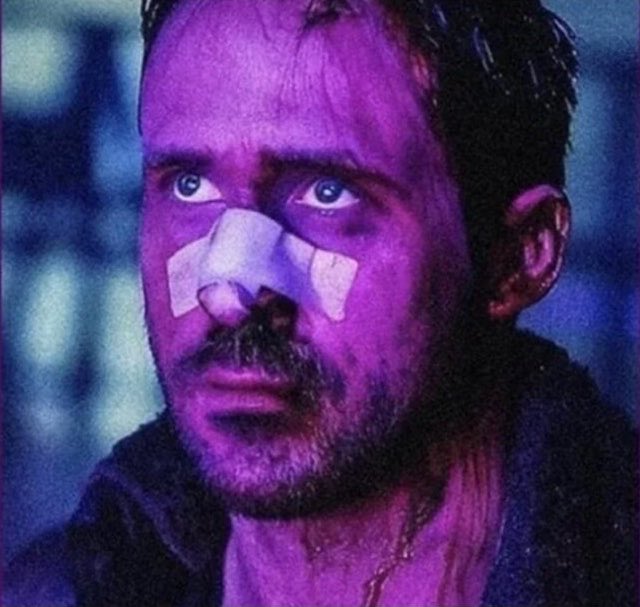 A close-up of a man with a bandaged nose, illuminated by purple lighting and wearing a dark jacket, captioned "Me reading this." The somber, weary expression on his face humorously conveys the relatable feeling of emotional exhaustion or reluctant attention when absorbing information from a post.