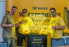 The image features three men standing next to a yellow banner with the word "WEEX" written on it, along with the phrase "WEEK EXPERIENCE". The men are wearing matching yellow shirts that say "WEEX", indicating they might be employees or representatives of the company. They appear to be posing for a photo in front of this banner and possibly attending an event related to the company's activities.