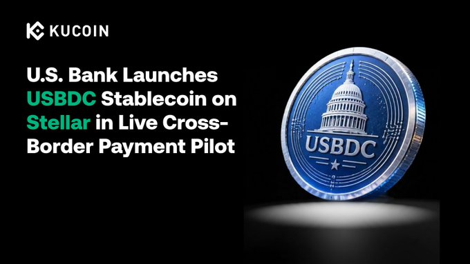 The image is a KuCoin promotional graphic with the headline "U.S. Bank Launches USBDC Stablecoin on Stellar in Live Cross-Border Payment Pilot," featuring a stylized blue USBDC coin emblazoned with the U.S. Capitol dome, visually representing the bank's newly piloted stablecoin for cross-border transactions on the Stellar blockchain.