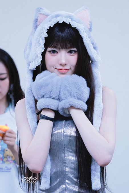 A young woman wearing a light blue fluffy cat-ear hood and matching paw gloves smiles at the camera, with a watermark reading 'r8jyc'.