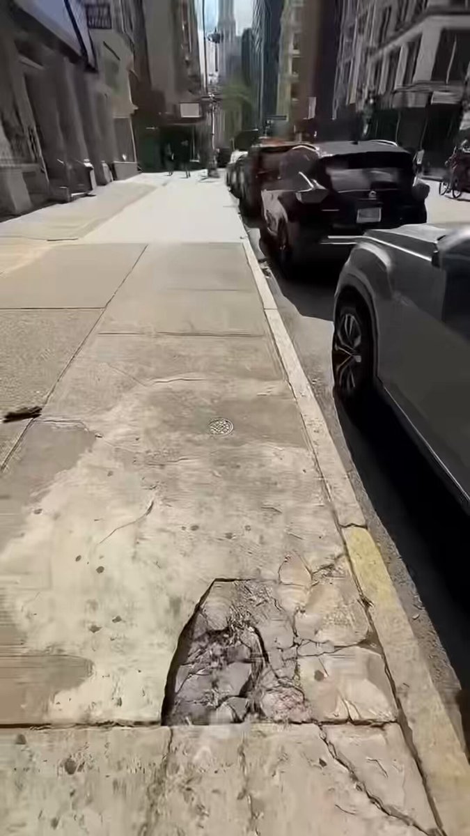 The image shows a sidewalk with a crack running through it. A car is parked next to this cracked sidewalk, and there are two people walking nearby. The caption of the image reads "Look, what I found! I thought I was cooked. Thanks, @solflare, for bringing me back to life." This message seems to be related to the cracked sidewalk in some way or another.