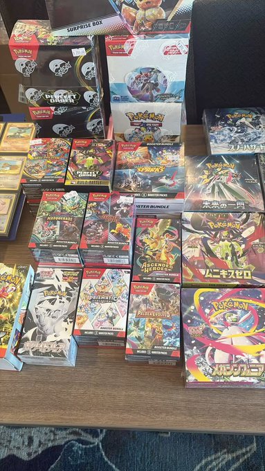 A large collection of Japanese Pokémon card products—including VSTAR Universe, VMAX Climax, S6H Eevee Heroes, and booster boxes—is displayed on a table, representing a tangible collectible investment compared to the volatile cryptocurrency market mentioned in the post. The post questions whether Pokémon cards might be a safer investment than crypto, as digital assets like SOL and BTC appear to be declining in value.