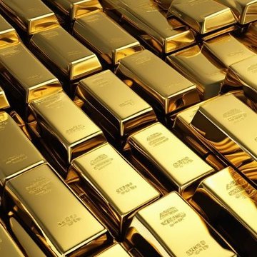 Stacked gold bars stamped 'FINE GOLD 999.9 NET WT 1000G' arranged in a dense pile, gleaming under warm lighting.