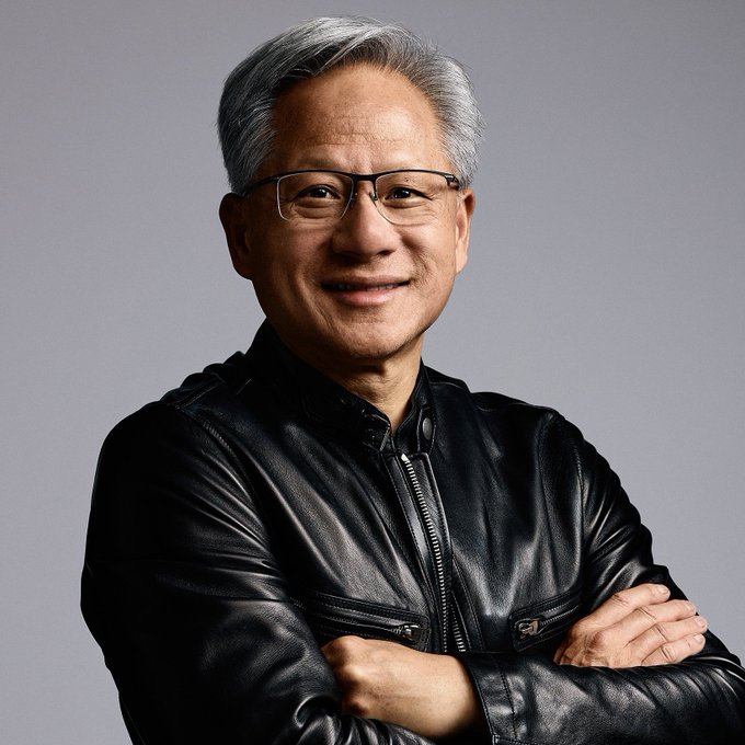 Nvidia CEO Jensen Huang is smiling confidently with arms crossed. The image accompanies news of his optimistic stance dismissing AI doomsday predictions, visually reinforcing his assured, unbothered demeanor about the technology's future.