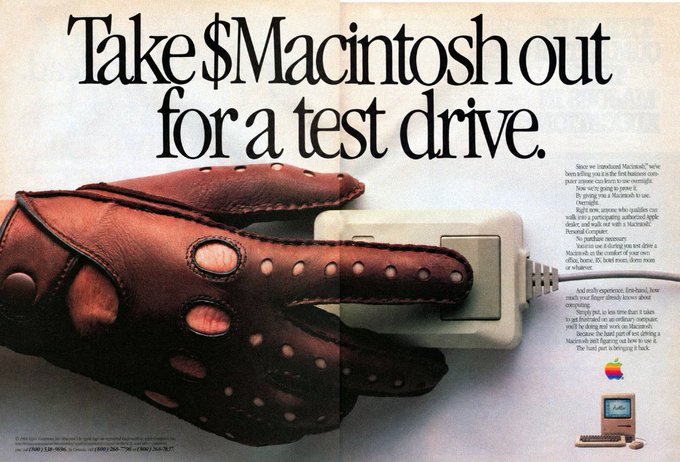A vintage Apple advertisement featuring the bold headline "Take $Macintosh out for a test drive" alongside an image of a brown leather driving glove holding a Macintosh mouse. The ad invites readers to test-drive the Macintosh computer, aligning with Apple's iconic "Think Different" marketing campaign.