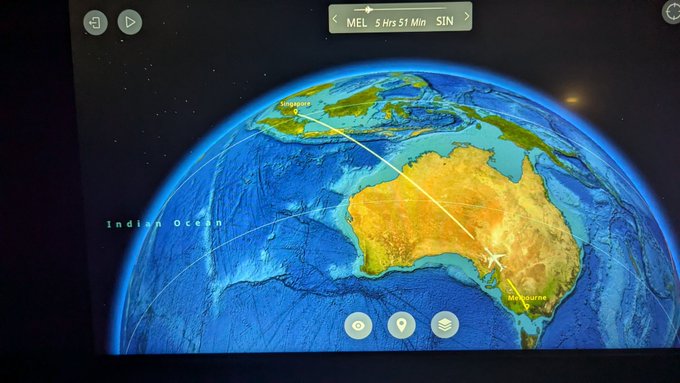 The image shows a map of the world with a focus on Australia and New Zealand. The screen displays a map of the world along with the names of some countries, including Australia and New Zealand. There are also icons representing airplanes flying over these countries. The text in the image reads "On my way to Vietnam for @Unchained Summit in Da Nang, will be reppin' all things Dogecoin". This suggests that someone is planning a trip to Australia or New Zealand using an airplane and might be interested in cryptocurrency as well.