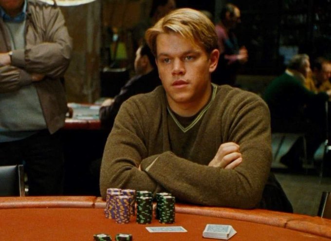 A young blonde man in a brown sweater sits at a poker table with stacks of colorful chips in front of him, intently focused on the game. The scene visually reinforces the post by depicting a poker match that serves as an unconventional entry point to introduce Solana—using the high-stakes energy of the card table to draw people into conversations about the blockchain.