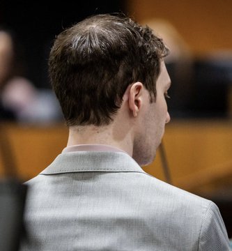 A man in a gray suit is shown from behind, seated in what appears to be a courtroom setting. The post references Tyler Robinson and a Polymarket prediction showing only a 42% chance of conviction for homicide, suggesting the image depicts Robinson during court proceedings.