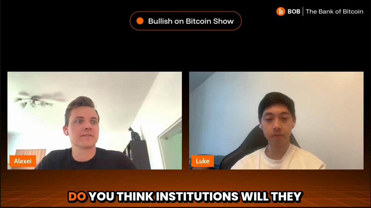 The image shows two men sitting at a table, having a conversation about Bitcoin and blockchain technology. The background of the image features a computer screen displaying a website or app related to Bitcoin and blockchain.