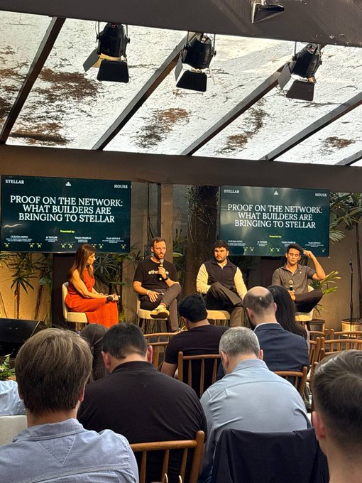 A panel discussion at an event titled 'Proof on the Network: What Builders Are Bringing to Stellar', with Stellar-branded screens and an audience watching four speakers.