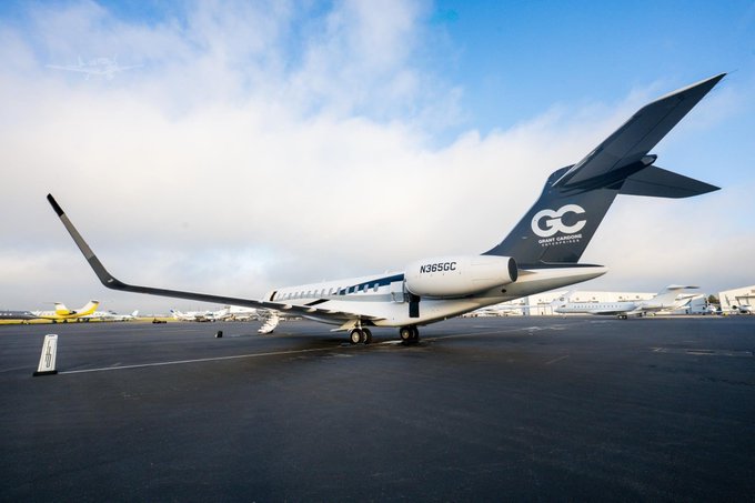A private jet marked "N365GC" with "GC" branding on the tail sits on a tarmac with other aircraft visible in the background.