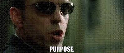 A still of actor Adrien Brody wearing sunglasses with the caption 'PURPOSE.'