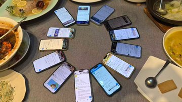Around a table with dishes, multiple smartphones are arranged in a circle, each displaying what appears to be NFT collection pages on Twitter, showing various Bored Ape Yacht Club (BAYC) and related profile accounts, reflecting the post's excitement about meeting fellow NFT community members in person.