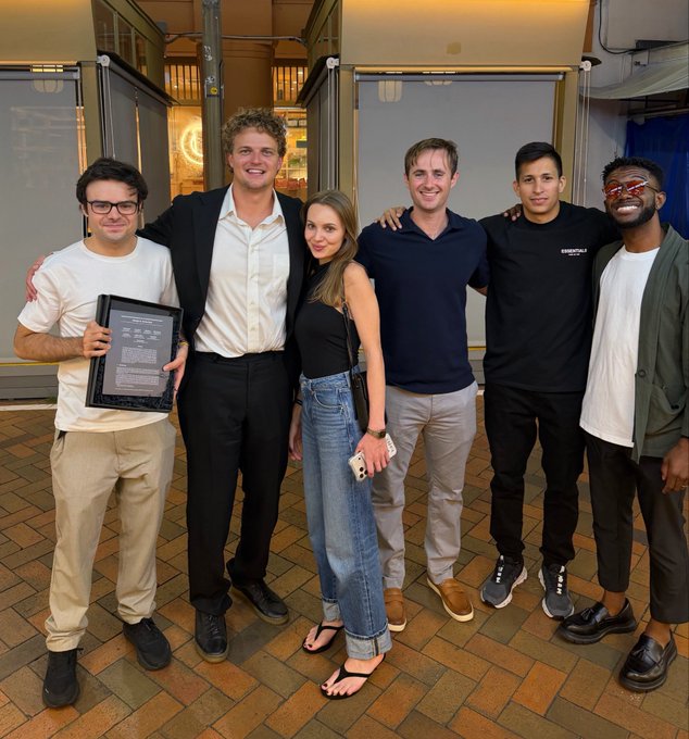 Six team members of Rollup pose together, with the person on the left holding a framed "Speculation Markets" award plaque, celebrating the team's six-year milestone and reflecting the post's tribute to their loyal, multi-skilled crew akin to a "Moneyball" team.