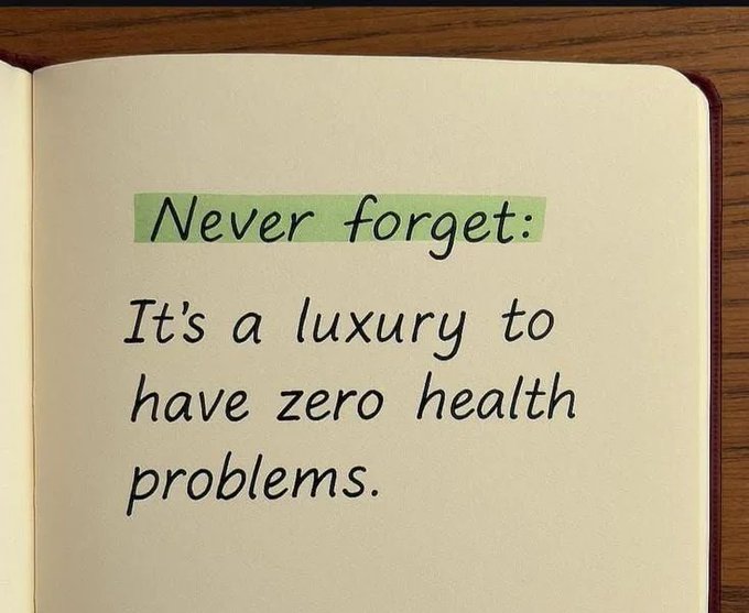 An open notebook with the handwritten message 'Never forget: It's a luxury to have zero health problems.' with the top phrase highlighted in light green.