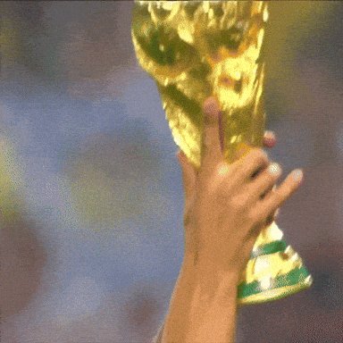 The image features a person's hand holding a golden trophy, possibly a soccer championship award or a similar recognition. The trophy appears to be made of gold with green trim around its edges. The background shows a blurred view of a stadium filled with people watching a game. There is also an element in the image that reads "fantasy world cup has landed on @Starknet 5 days left limited spots link in bio". This suggests that the trophy might have been won by someone from a fantasy football team, and they are celebrating their victory at a live event or gathering of fans.